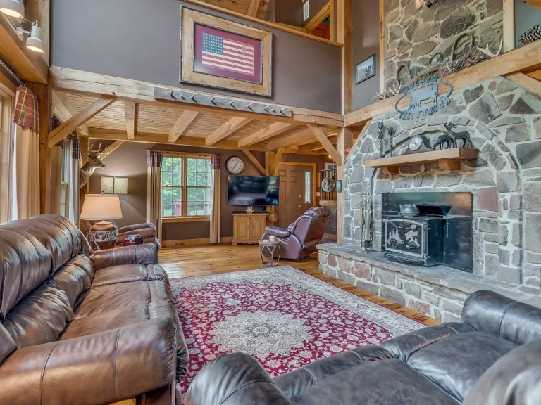 Timber frame living room with stone fireplace and leather sofas