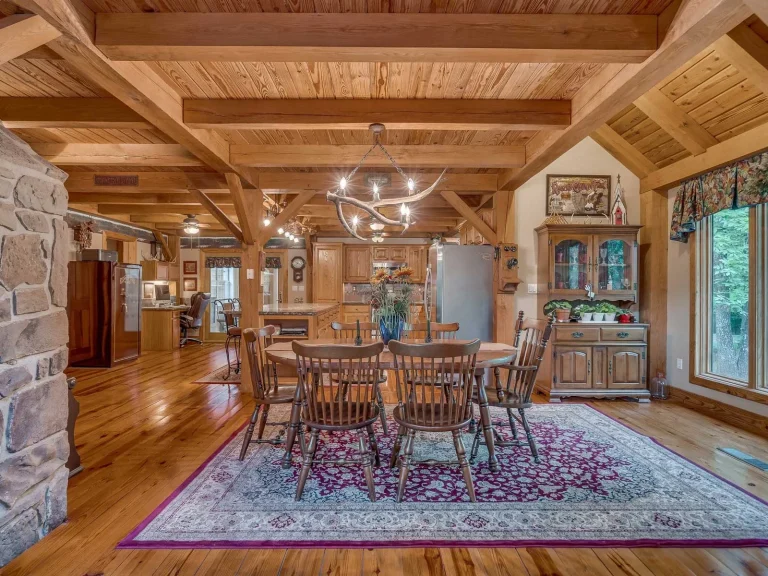 Timber frame dining room with beamed pine ceiling and stone wall