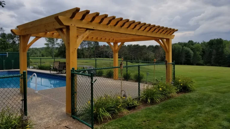 Timber frame pergola with notched rafter tails beside a swimming pool