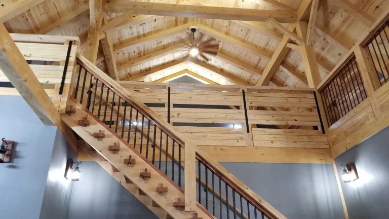 Timber frame loft with pine cathedral ceiling, exposed rafters and staircase