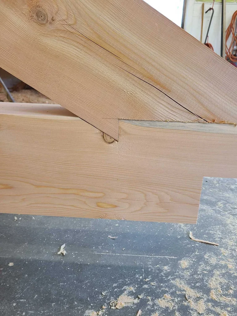 Close-up of a timber frame rafter seat cut onto a plate beam