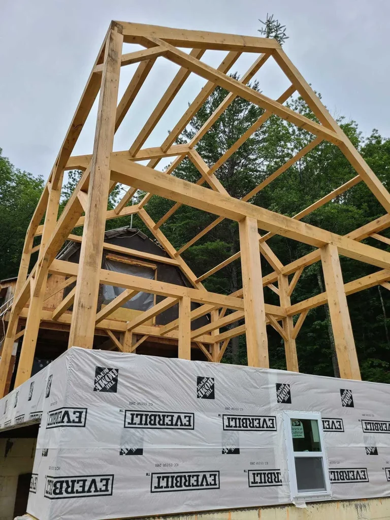 Tall timber frame gable raised above a wrapped first floor