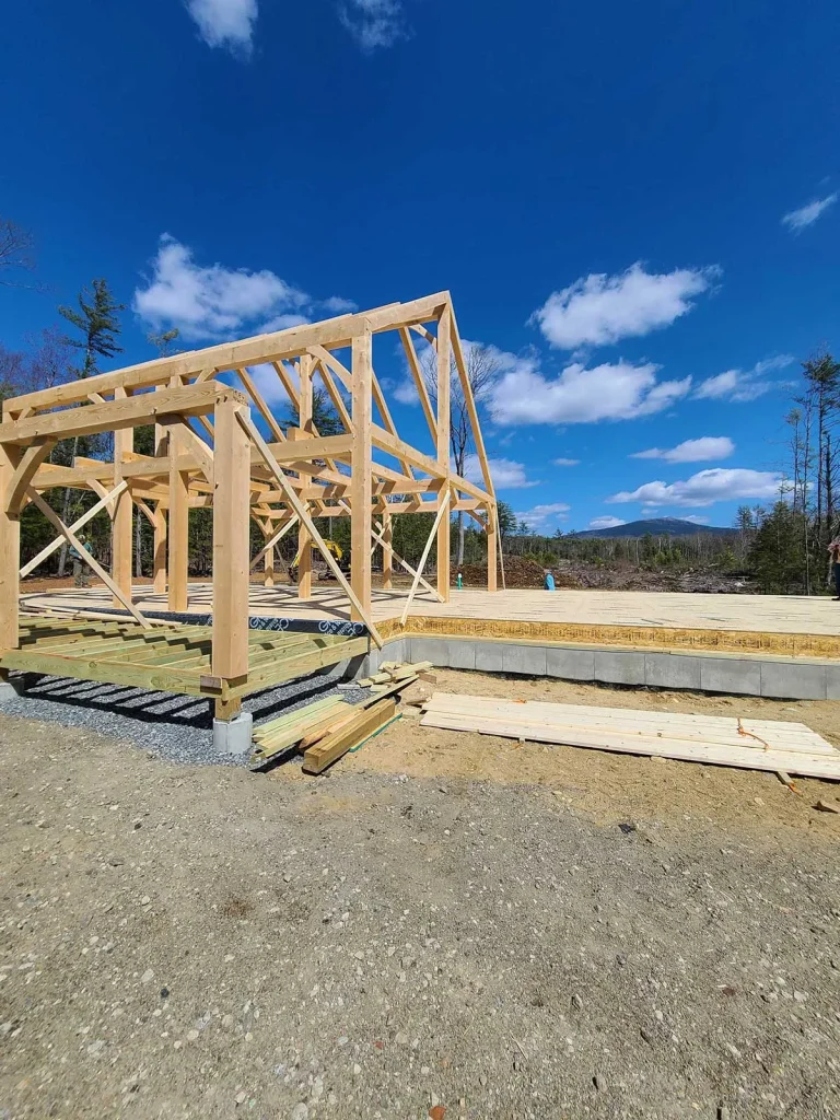Small timber frame structure raised on a gravel site with mountain view
