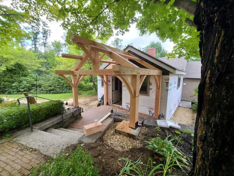 Timber frame entry porch with curved braces on a cottage
