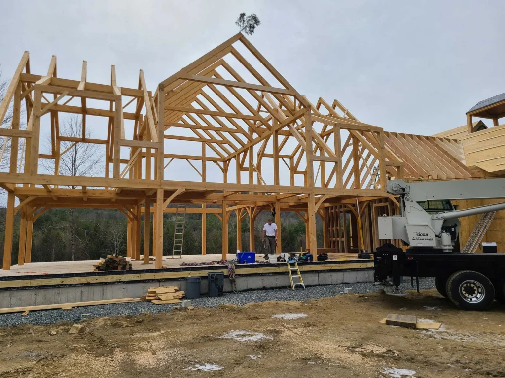 Large timber frame home with tall center gable raised by crane