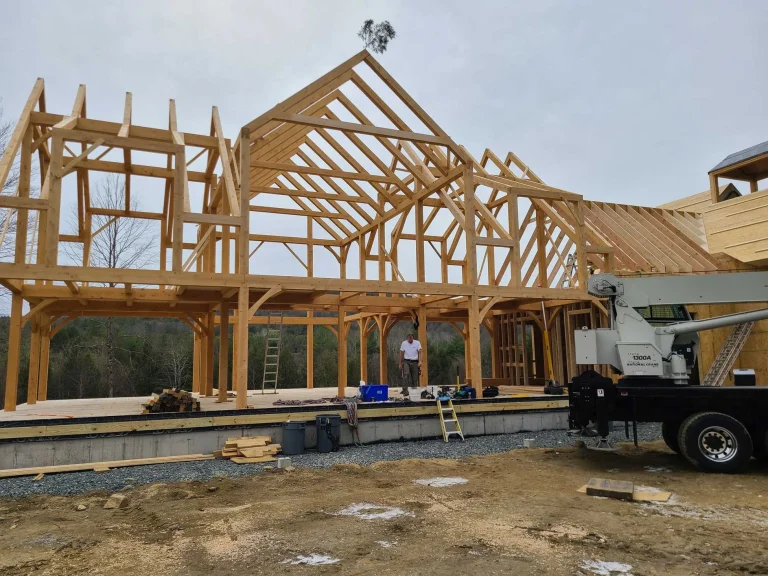 Large timber frame home with tall center gable raised by crane