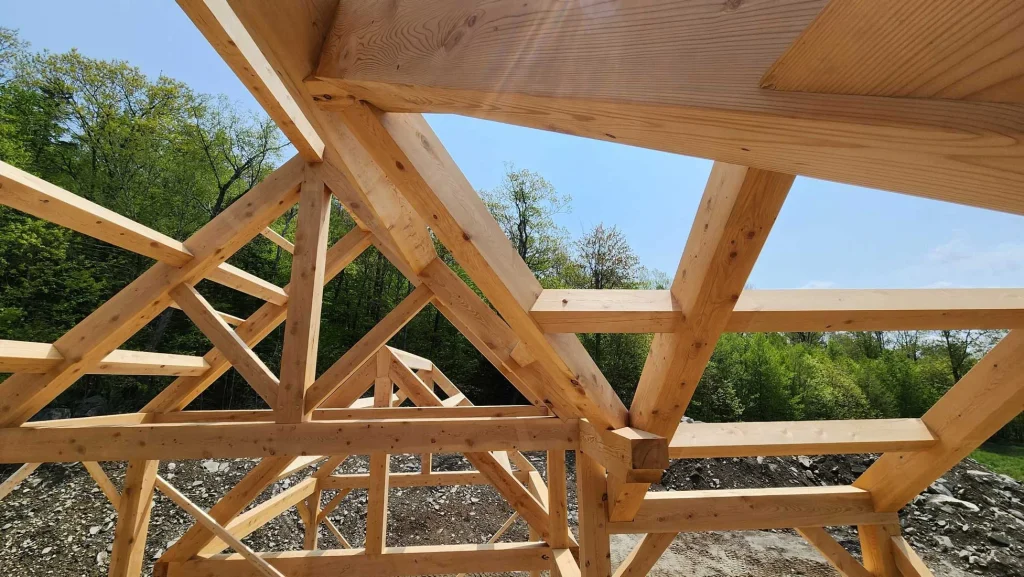 Timber frame braces and rafters close up against a blue sky
