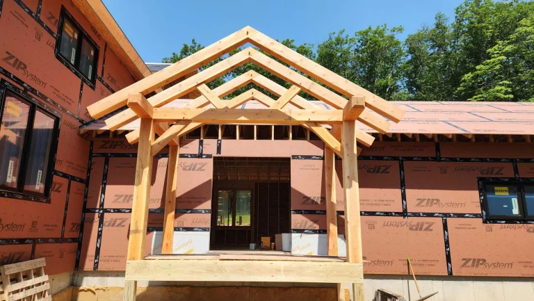 Timber frame entry porch with layered gable trusses on a new home