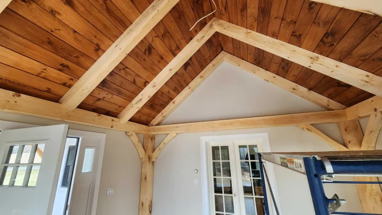 Timber frame king post truss under a pine tongue and groove ceiling