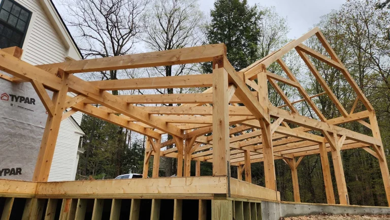 Timber frame porch structure attached to a house under construction