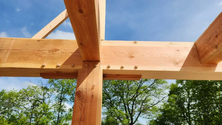 Timber frame post and beam joint with wooden pegs viewed from below