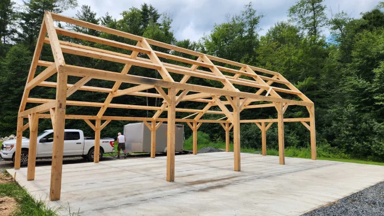 Long timber frame garage with braced posts on a new concrete slab