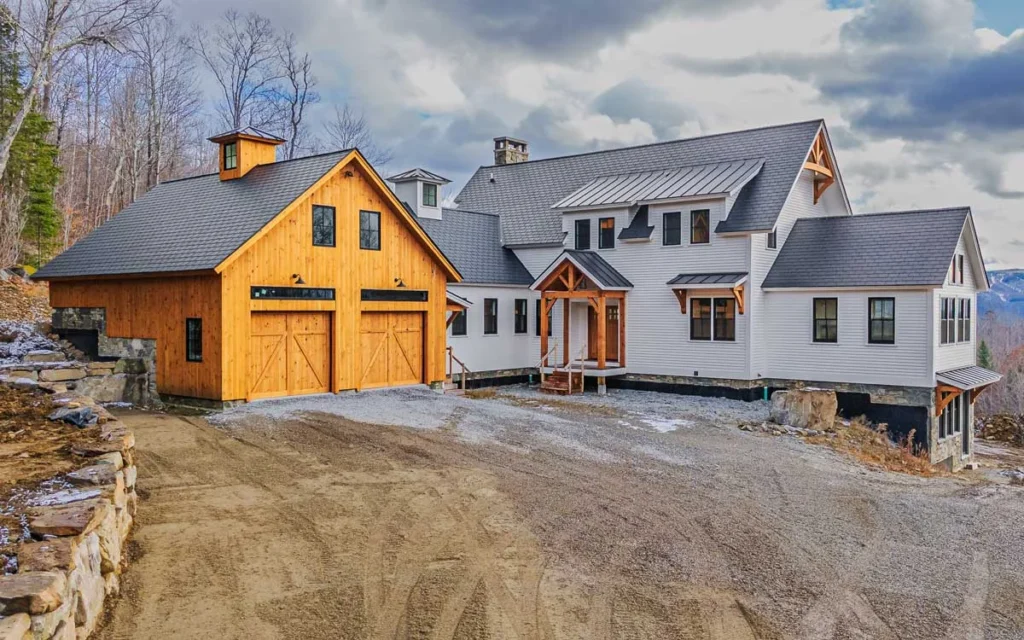 New England farmhouse with timber frame entry porch and post and beam garage