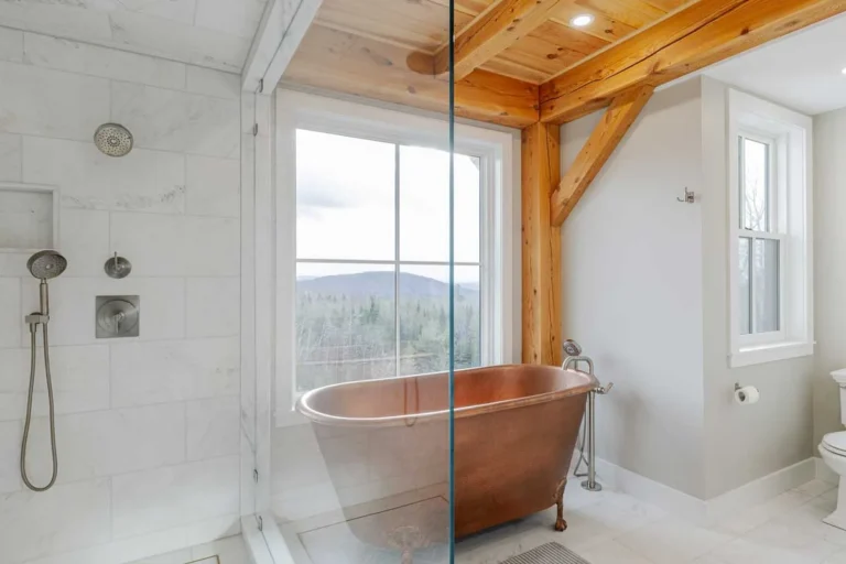 Timber frame bathroom with copper soaking tub, glass shower and mountain view window
