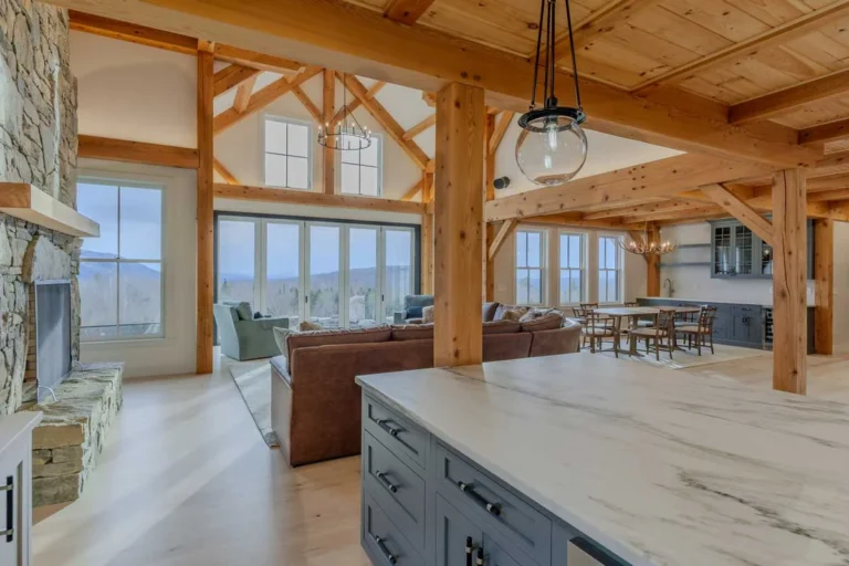 Open timber frame kitchen and great room with stone fireplace and mountain view windows