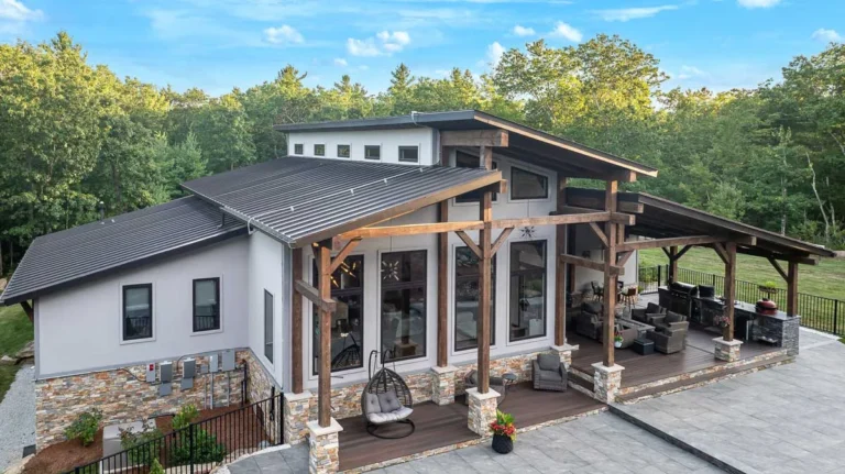 Modern home exterior with timber frame covered porch on a stone patio