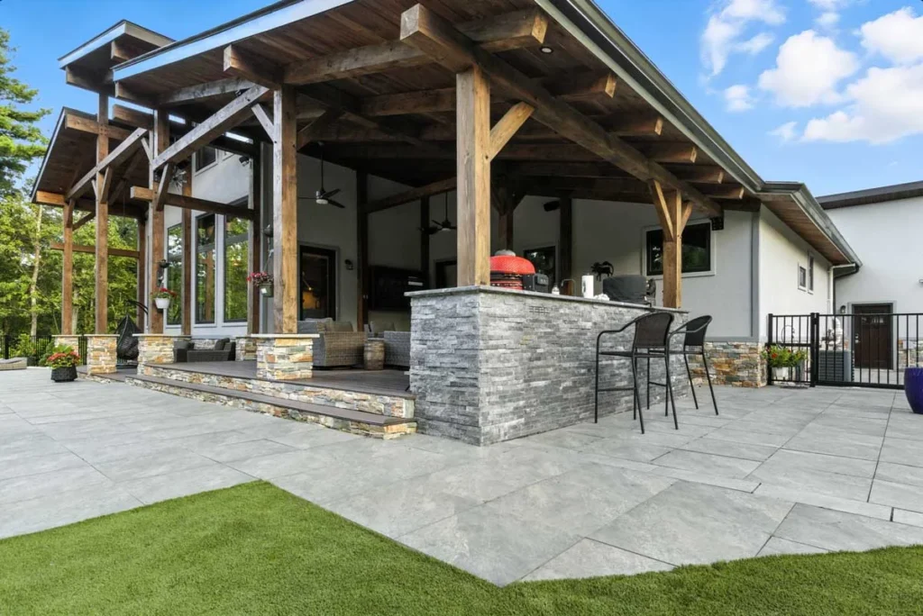Timber frame covered patio with stone outdoor kitchen bar