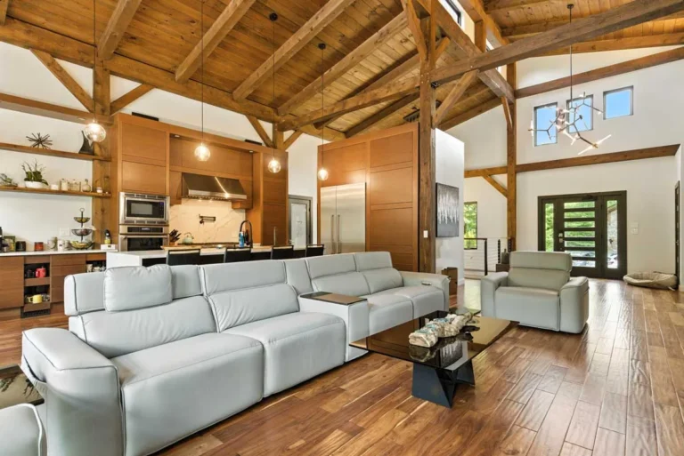Open timber frame living room and kitchen with exposed king post trusses
